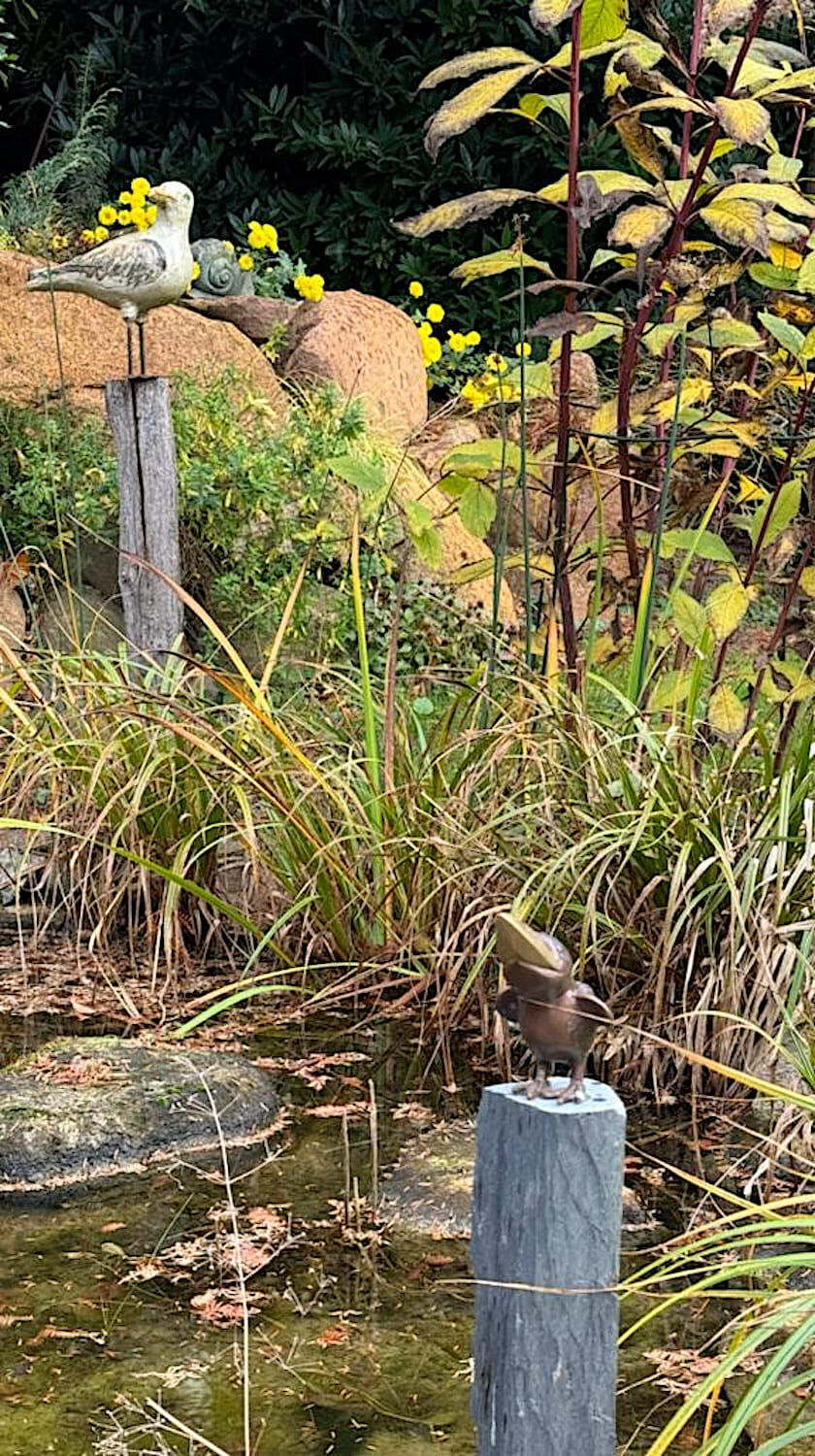 Grimmen: Keramikmöve auf Bunenholzstele und Rabe auf Schieferpodest